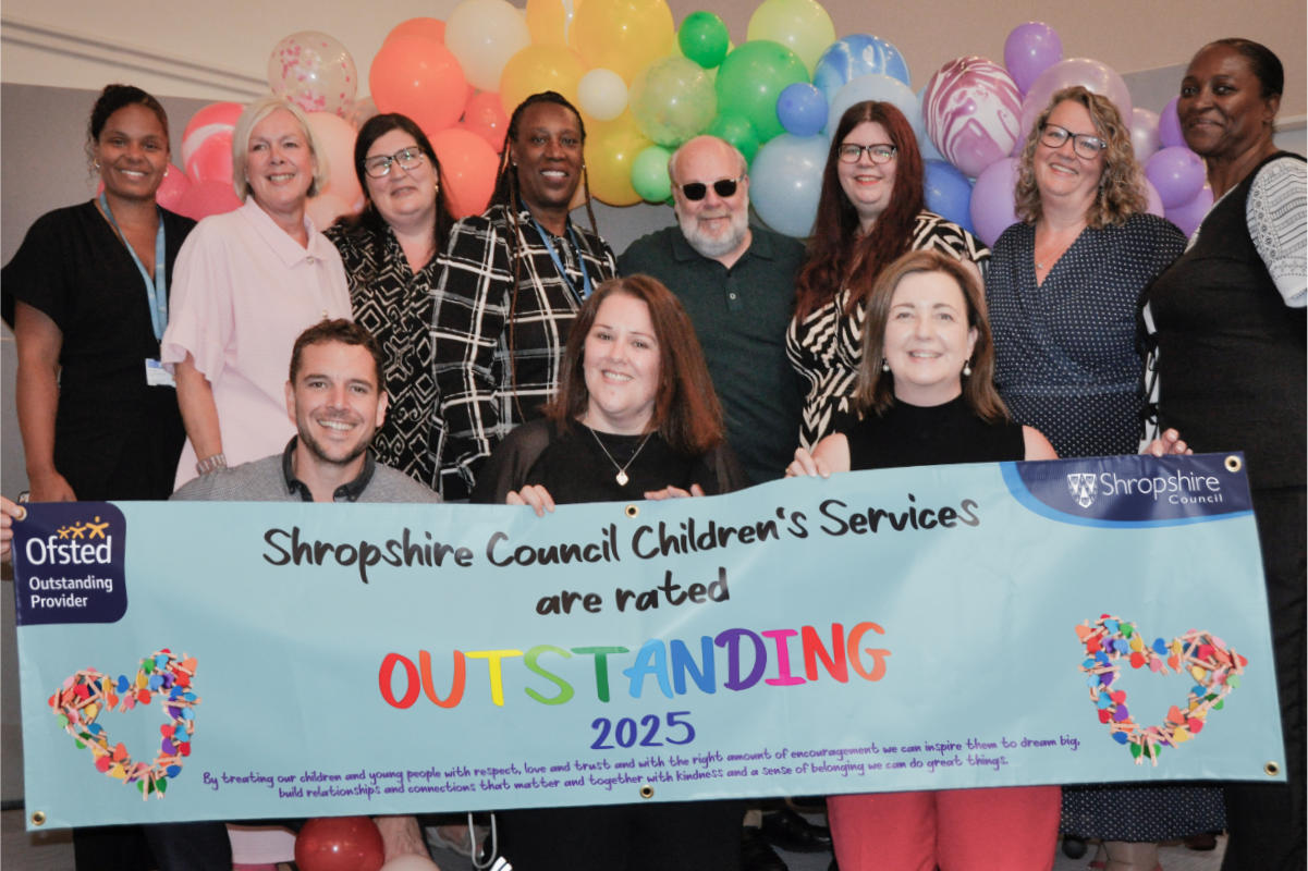 Shropshire Fostering team holding a banner which reads "Shropshire Council Children's Services are rated Outstanding 2025 - Ofsted Outstanding Provider"